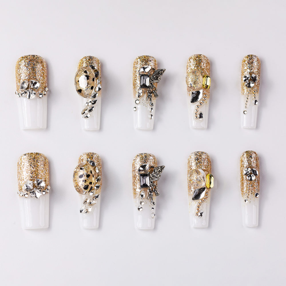 Luxurious gold glitter press-on nails adorned with silver and rhinestone embellishments, featuring unique metallic accents and elegant designs for a glamorous and chic look.