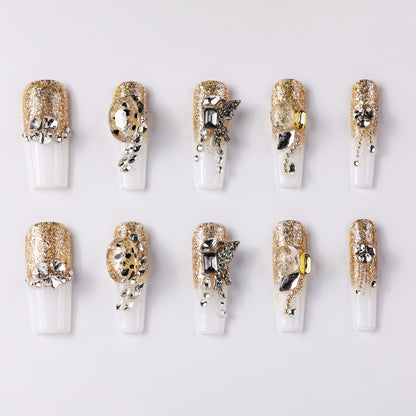 Luxurious gold glitter press-on nails adorned with silver and rhinestone embellishments, featuring unique metallic accents and elegant designs for a glamorous and chic look.